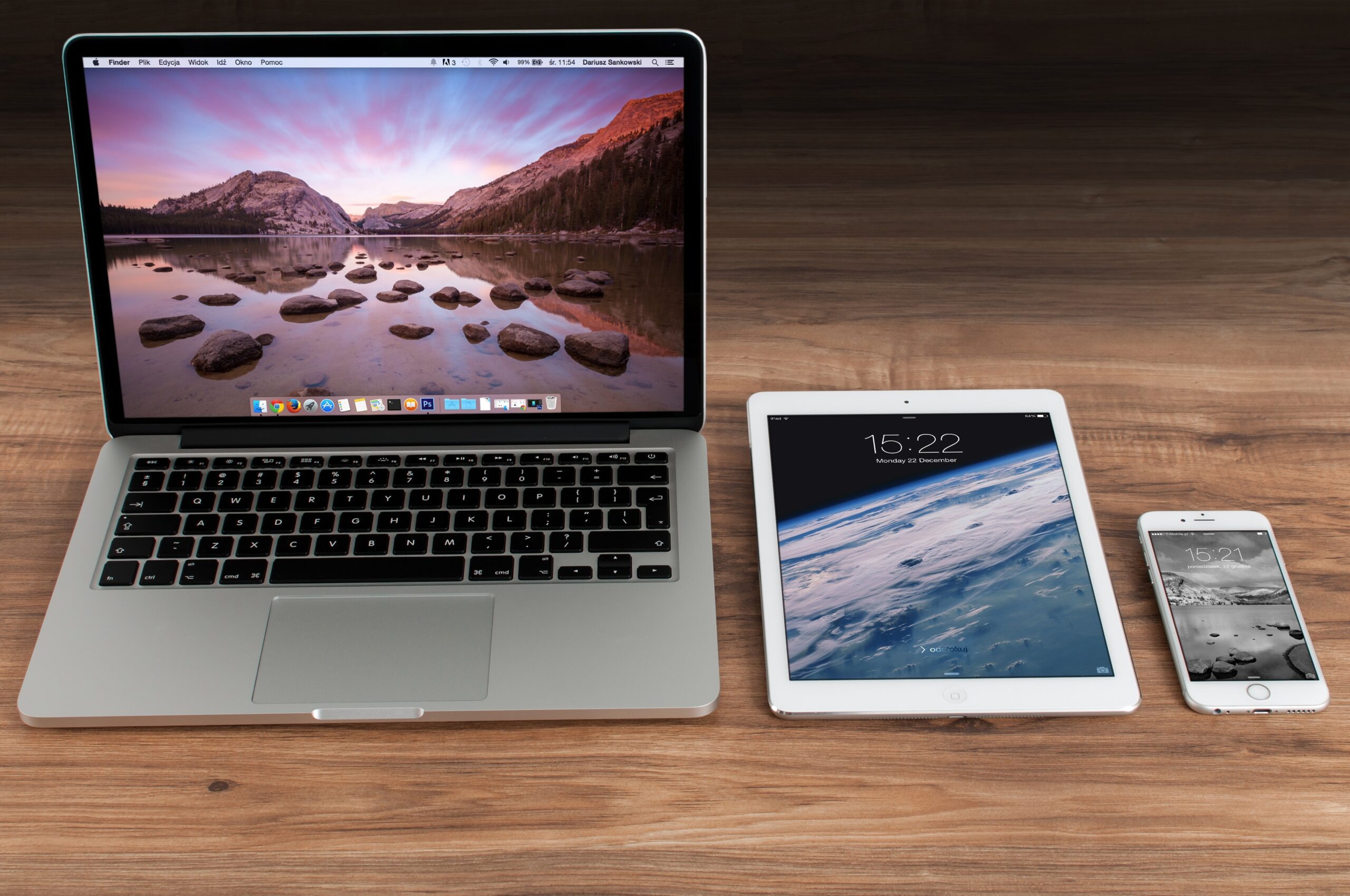 A laptop, tablet and a cellphone in the table